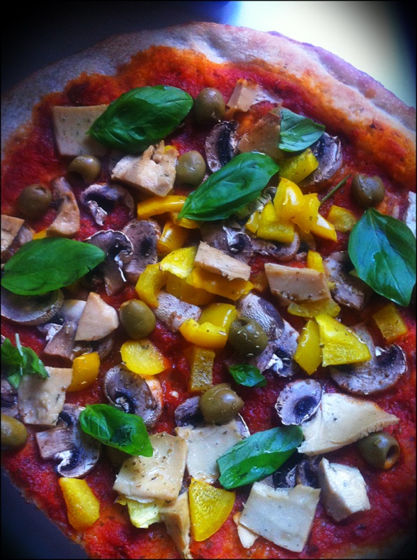 Pizza vegan maison avec poivrons jaunes, champignons, olives, fromage végétal - faut bien le terminer et basilic. 